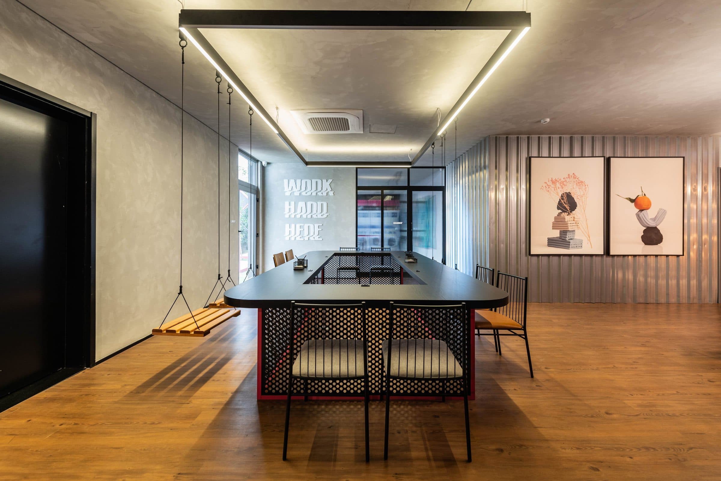 Coworking com mesa compartilhada e iluminação linear